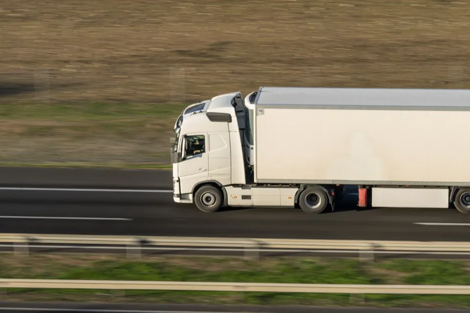 Imagen con técnica de dinamismo que muestra un trailer de carga yendo a toda velocidad para realizar la prueba y no caer en una retención de mercancía en aduana